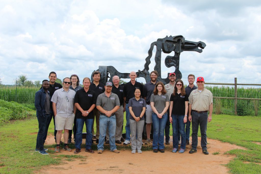 Soybean team standing in front of the iron horse at Iron Horse Farm.