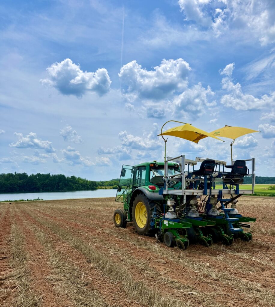 The planter in a field on a sunny day, with a pond visible in the background.